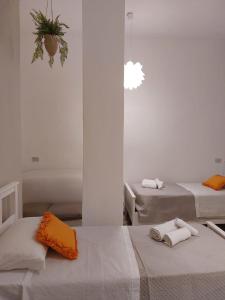 2 łóżka w białym pokoju z ręcznikami w obiekcie Casa Costanzo w mieście Capaci