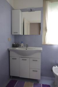 łazienka z białą umywalką i lustrem w obiekcie Casa Costanzo w mieście Capaci +8 zdjęć