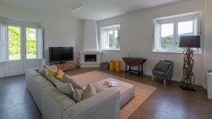 a living room with a couch and a tv at Villa Terre Normanne 16, Emma Villas in Castiglione di Sicilia