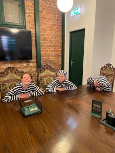 tre persone sedute a un tavolo con le braccia incrociate di Fengselshotellet i Arendal ad Arendal