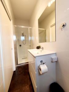 a white bathroom with a sink and a shower at Port Arthur Villas in Port Arthur
