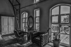 ein Wohnzimmer mit einem Stuhl, einem Tisch und einem Spiegel in der Unterkunft Badacsony Loft in Badacsonytomaj