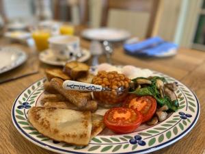un plato de comida con pan y tomates en una mesa en South Craighall B&B en Eaglesham