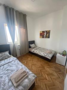 1 dormitorio con 2 camas y ventana en Apartmani Home en Zaječar