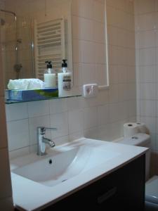 y baño con lavabo blanco y espejo. en LA NURSERY DE MAS GUILLO, en Sant Quintí de Mediona
