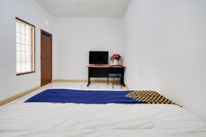 ein großes Bett in einem Zimmer mit einem Schreibtisch in der Unterkunft OYO 91546 Dewi Sudirman Homestay in Bandung
