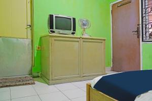 Habitación con TV en la parte superior de un armario. en SPOT ON 91543 Pondok Denki 11, en Bandung