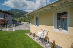 a house with two chairs sitting on the front yard at Haus NIEDERREITER in Bischofshofen