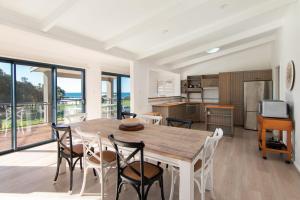 a kitchen and dining room with a wooden table and chairs at Close to Coast in Forster