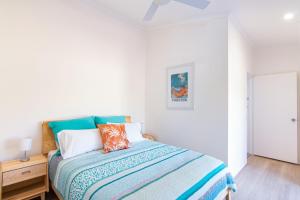 a bedroom with a bed with a blue and white comforter at Close to Coast in Forster