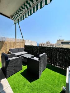 a patio with two chairs and a table and grass at 2 Bedrooms - Sea View Apartment in Nice