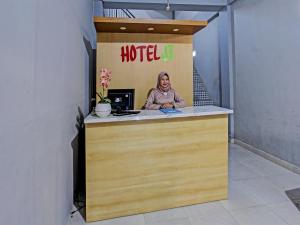 a woman sitting at a counter in a hotel room at OYO 91210 Hotel J3 in Lombok