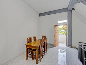 a dining room with a wooden table and chairs at OYO 91210 Hotel J3 in Lombok