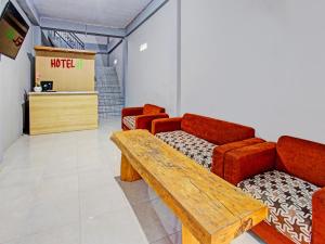 a waiting room with red chairs and a wooden table at OYO 91210 Hotel J3 in Lombok