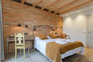 1 dormitorio con cama y pared de ladrillo en Casona Canto Llano, 