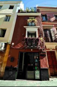 edificio rosso con balcone e finestra di Typical Sevillan 2 bedroom unit a Siviglia