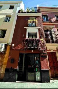 czerwony budynek z balkonem i oknem w obiekcie Typical Sevillan 2 bedroom unit w Sewilli