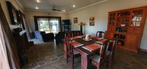 a living room with a dining room table with chairs at Berlouri Guest House in Hekpoort