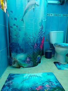 a bathroom with a dolphin shower curtain and a toilet at MultiAventura en Agüimes in Agüimes