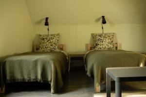 two beds sitting next to each other in a room at Coastal Home Piedāgi Ūši in Kolka