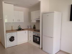 een keuken met een wasmachine en een witte koelkast bij Golf del Sur-1 bedroom poolside apartment-sleeps 4 in San Miguel de Abona