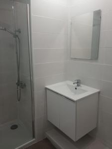 een witte badkamer met een wastafel en een douche bij Golf del Sur-1 bedroom poolside apartment-sleeps 4 in San Miguel de Abona