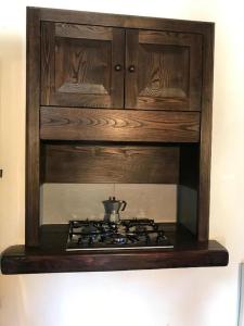 una estufa en un armario de madera con una tetera en Il Pianetto, en Pieve Fosciana
