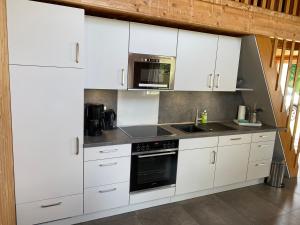 uma cozinha com armários brancos e um forno com placa de fogão em THE KREIDESEE 47 - Hemmoor em Hemmoor
