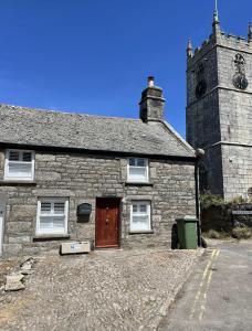an old stone building with a clock tower at Cobble Cottage in St Just