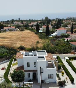a white house with a view of a town at St. Georgiana Villa 7 in Peyia