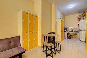 Habitación con mesa y taquillas amarillas. en OYO 91532 Malioboro Guesthouse, en Yogyakarta