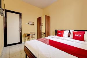1 dormitorio con 1 cama grande con almohadas rojas en OYO 91532 Malioboro Guesthouse, en Yogyakarta