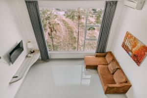 a living room with a couch and a large window at The Salak Style Hotel in Denpasar