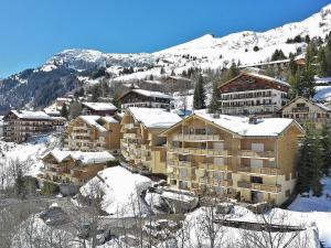 a group of buildings in the snow with a mountain at Appartement Le Grand-Bornand, 2 pièces, 4 personnes - FR-1-391-95 in Le Grand-Bornand