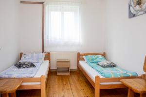 1 dormitorio con 2 camas, mesa y ventana en Prenoćište Vanja, en Padej