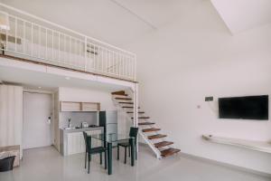 a living room with a table and a staircase at The Salak Style Hotel in Denpasar