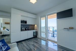 uma cozinha com armários brancos e vista para o oceano em I Bordin Home em Nettuno