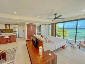 a bedroom with a bed and a kitchen with a view at Maui Palms in Korolevu