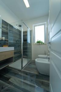 a bathroom with a shower and a toilet and a sink at I Bordin Home in Nettuno