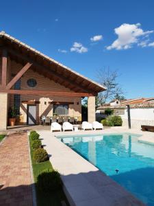 a swimming pool with chairs next to a building at Mi lugar favorito in Torrejón del Rey
