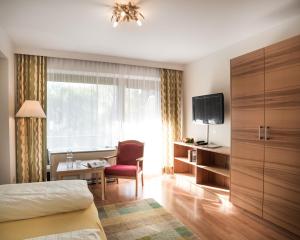 Habitación de hotel con cama, escritorio y ventana en Appartementhaus Gastein inklusive Alpentherme gratis en Bad Hofgastein