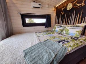 1 dormitorio con 1 cama con pared de madera en ReindeerNook, en Kuusamo