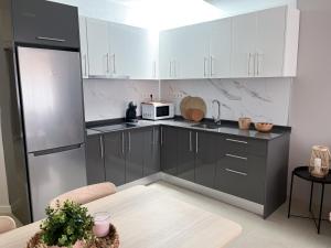 une cuisine avec des armoires noires et blanches et un micro-ondes dans l'établissement Club Apartments by Grupo Compostelana 5, à Puerto de la Cruz
