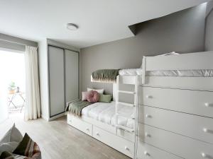 une chambre avec un lit superposé blanc et une commode dans l'établissement Club Apartments by Grupo Compostelana 5, à Puerto de la Cruz