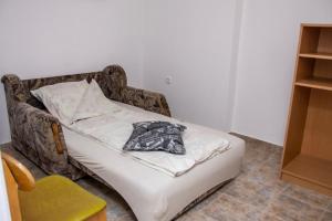 a bed in a room with a blanket on it at Prenoćište Vanja in Padej