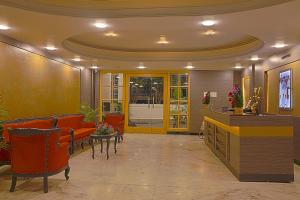 a lobby with a waiting room with orange chairs at Hotel Marvic in Tiruchchirāppalli