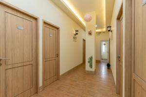 a hallway with wooden doors and a hallway with wood floors at RedDoorz Plus Near RS Royal Taruma Grogol in Jakarta +18 photos