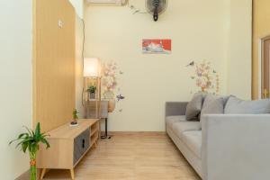 a living room with a couch and a table at RedDoorz Plus Near RS Royal Taruma Grogol in Jakarta