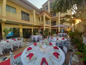 a banquet hall with white tables and red napkins at Afilux Residencial in Luanda