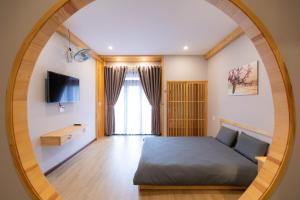 um quarto com uma cama e um espelho redondo em Nguyễn Tài Hostel & Coffee Đà Lạt em Da Lat